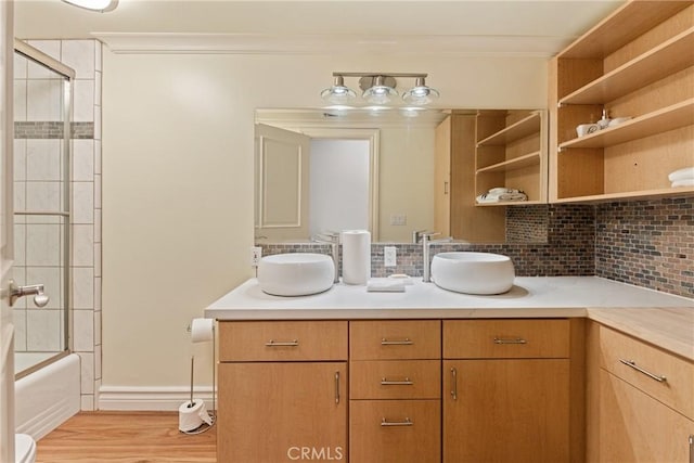 1377 Knoll Rd, Redlands, CA 92373 - bathroom featuring double vanity, backsplash, wood finished floors, enclosed tub / shower combo, and crown molding