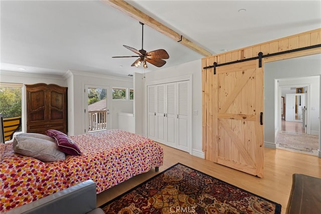 1377 Knoll Rd, Redlands, CA 92373 - bedroom featuring multiple windows, light wood-style flooring, access to exterior, a barn door, and crown molding
