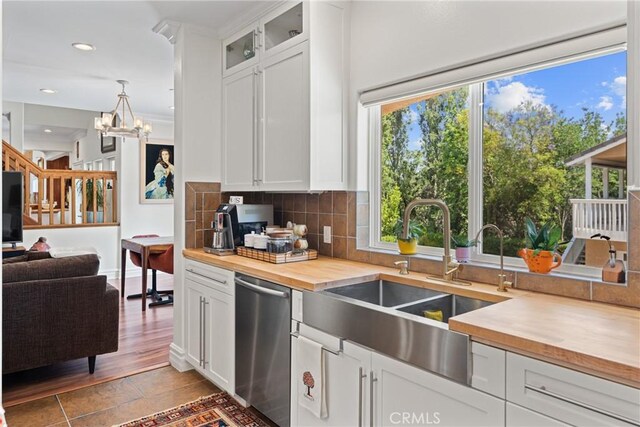 1377 Knoll Rd, Redlands, CA 92373 - kitchen featuring stainless steel dishwasher, butcher block counters, decorative backsplash, white cabinets, and glass insert cabinets