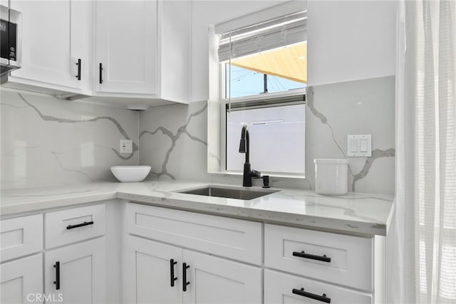 2129 N Pepper St, Burbank, CA 91505 - kitchen with a sink, white cabinetry, light stone counters, and decorative backsplash