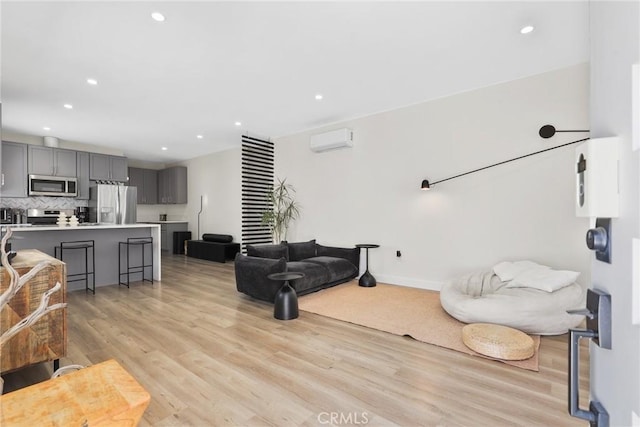 2129 N Pepper St, Burbank, CA 91505 - living room featuring light wood finished floors, recessed lighting, a wall mounted air conditioner, and baseboards