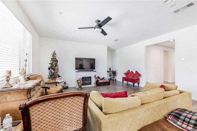 29485 Whitewood St, Menifee, CA 92584 - living room featuring wood finished floors, a ceiling fan, a glass covered fireplace, and recessed lighting