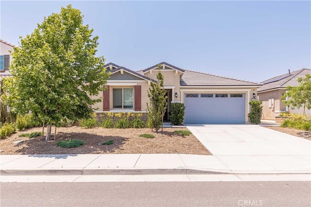 29485 Whitewood St, Menifee, CA 92584 - view of front of house featuring an attached garage, concrete driveway, a tiled roof, stucco siding, and stone siding