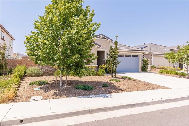 29485 Whitewood St, Menifee, CA 92584 - view of property hidden behind natural elements featuring an attached garage, concrete driveway, stucco siding, and a tile roof