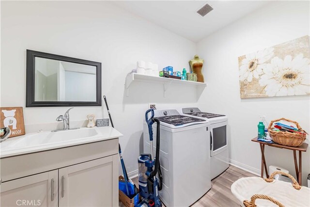 29485 Whitewood St, Menifee, CA 92584 - laundry area featuring washer and dryer, light wood-type flooring, and cabinet space