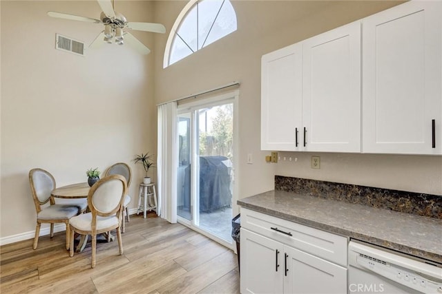 41555 Avenida De La Reina, Temecula, CA 92592 - kitchen featuring white dishwasher, dark countertops, light wood-style floors, white cabinets, and a high ceiling
