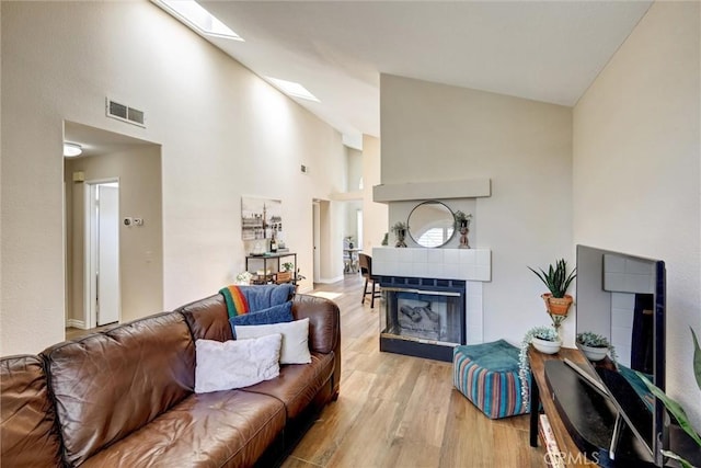41555 Avenida De La Reina, Temecula, CA 92592 - living room with high vaulted ceiling, light wood-type flooring, a skylight, and a fireplace