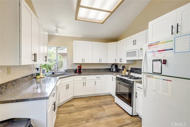 41555 Avenida De La Reina, Temecula, CA 92592 - kitchen with white appliances, white cabinetry, vaulted ceiling, and light wood-style flooring