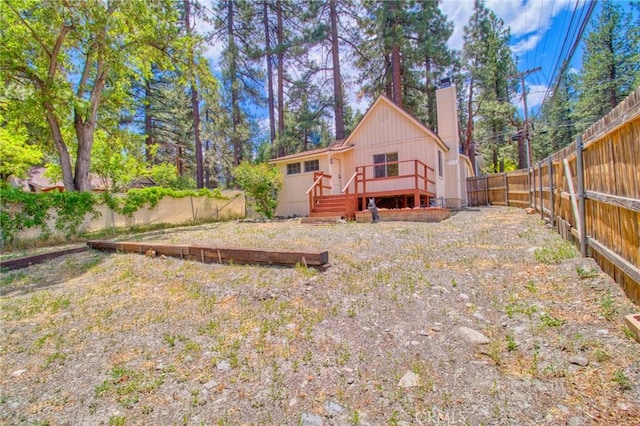 1131 Apple Ave, Wrightwood, CA 92397 - rear view of house featuring a chimney, a wooden deck, and a fenced backyard