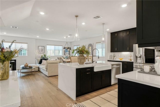27723 S Grandview Way, San Pedro, CA 90732 - kitchen with dark cabinets, stainless steel appliances, light countertops, light wood-style floors, and recessed lighting