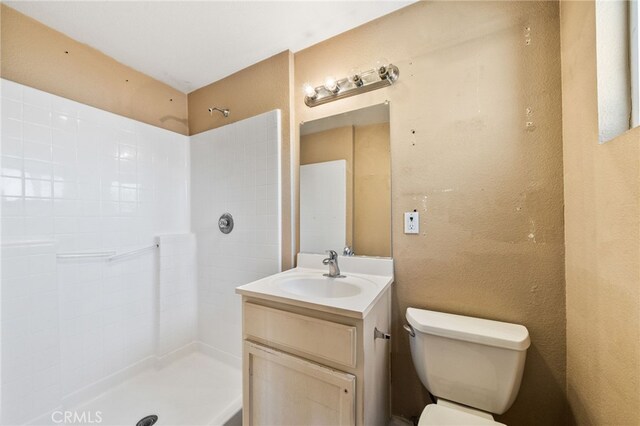 5294 Yosemite Dr, San Bernardino, CA 92407 - bathroom featuring a tile shower, vanity, and a textured wall
