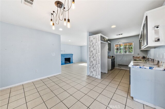 5294 Yosemite Dr, San Bernardino, CA 92407 - kitchen with light countertops, a fireplace, light tile patterned flooring, decorative light fixtures, and open floor plan