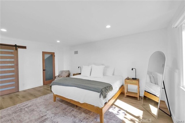 1923 Hollyvista, Los Angeles, CA 90027 - bedroom with a barn door, recessed lighting, and wood finished floors