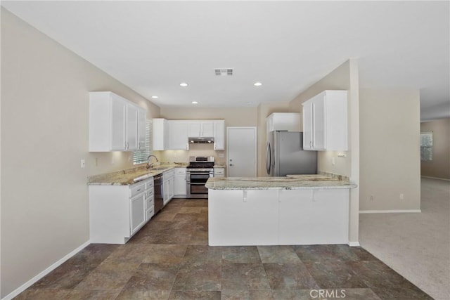 31713 Pompei Ln, Winchester, CA 92596 - kitchen with appliances with stainless steel finishes, a peninsula, white cabinetry, under cabinet range hood, and light stone countertops