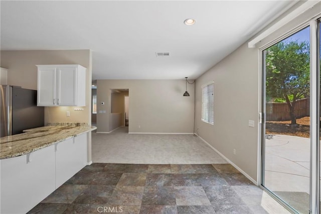 31713 Pompei Ln, Winchester, CA 92596 - kitchen with healthy amount of natural light, white cabinets, freestanding refrigerator, light stone counters, and recessed lighting