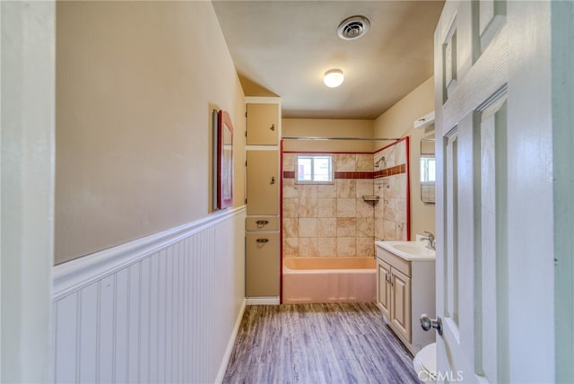 503 California Ave, Needles, CA 92363 - full bathroom featuring vanity, wood finished floors, shower / bathtub combination, and a wainscoted wall
