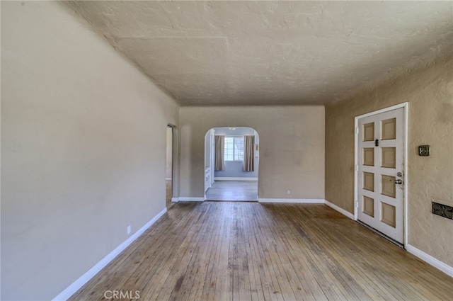 503 California Ave, Needles, CA 92363 - spare room with arched walkways, hardwood / wood-style flooring, and baseboards