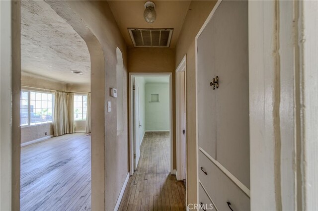 503 California Ave, Needles, CA 92363 - hallway with hardwood / wood-style flooring, arched walkways, and baseboards