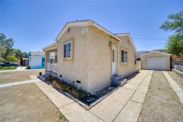 503 California Ave, Needles, CA 92363 - view of side of property with crawl space, stucco siding, driveway, an outdoor structure, and a garage