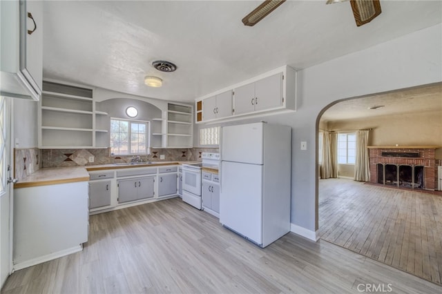 503 California Ave, Needles, CA 92363 - kitchen featuring white appliances, open shelves, arched walkways, a sink, and plenty of natural light
