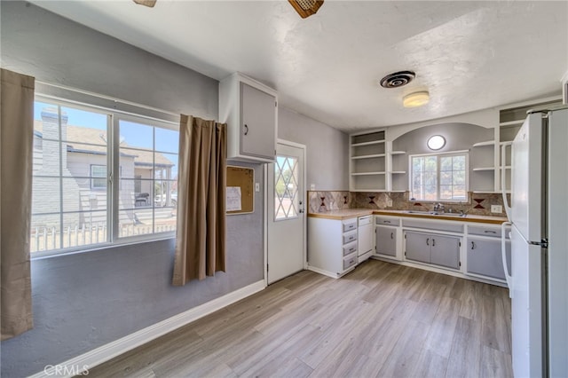 503 California Ave, Needles, CA 92363 - kitchen featuring open shelves, freestanding refrigerator, light wood finished floors, and tasteful backsplash