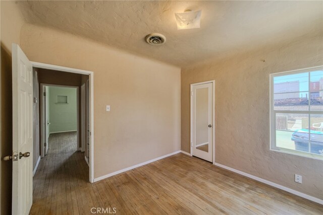 503 California Ave, Needles, CA 92363 - spare room with hardwood / wood-style flooring, baseboards, and a textured wall