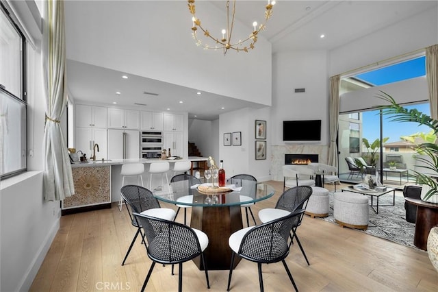 2004 Grant Ave Unit B, Redondo Beach, CA 90278 - dining space featuring a premium fireplace, light wood-style flooring, a towering ceiling, recessed lighting, and a chandelier