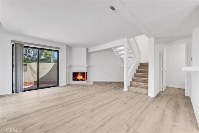 13104 Glen Ct Unit 28, Chino Hills, CA 91709 - unfurnished living room featuring wood finished floors, stairway, and a warm lit fireplace