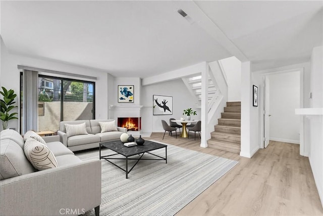 13104 Glen Ct Unit 28, Chino Hills, CA 91709 - living area with stairs, light wood-type flooring, and a lit fireplace