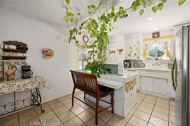 38614 Puerta Ave, Palmdale, CA 93550 - kitchen featuring tile counters, white cabinetry, light tile patterned floors, freestanding refrigerator, and recessed lighting