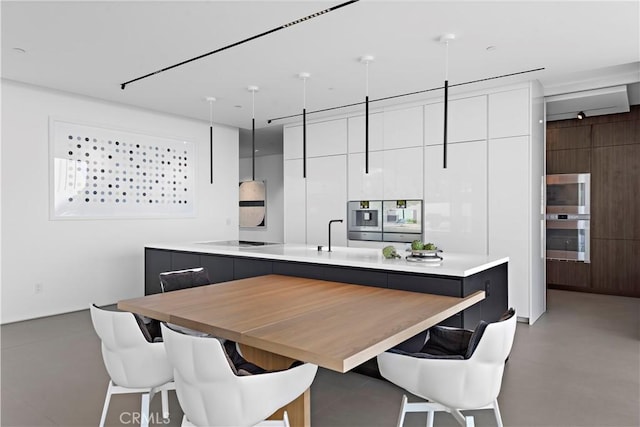 2460 Monaco Dr, Laguna Beach, CA 92651 - kitchen featuring modern cabinets, white cabinetry, light countertops, a kitchen bar, and black electric stovetop