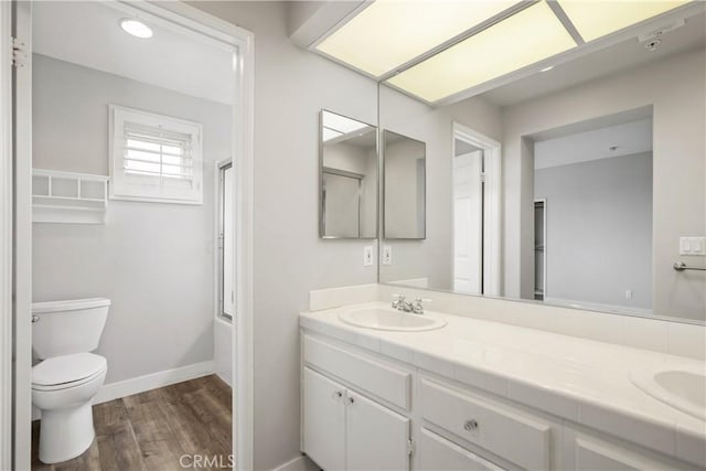 8308 Atlanta Ave Unit 101, Huntington Beach, CA 92646 - full bath featuring double vanity, wood finished floors, toilet, baseboards, and shower / bath combination with glass door