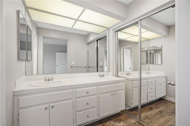8308 Atlanta Ave Unit 101, Huntington Beach, CA 92646 - bathroom featuring double vanity and wood finished floors