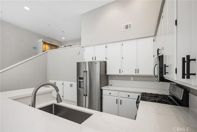 8308 Atlanta Ave Unit 101, Huntington Beach, CA 92646 - kitchen with stainless steel appliances, a sink, recessed lighting, white cabinets, and light stone counters