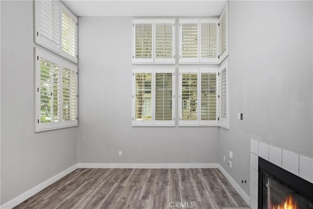8308 Atlanta Ave Unit 101, Huntington Beach, CA 92646 - empty room with wood finished floors, baseboards, and a tiled fireplace