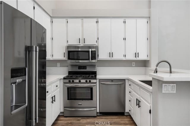 8308 Atlanta Ave Unit 101, Huntington Beach, CA 92646 - kitchen featuring appliances with stainless steel finishes, white cabinets, a sink, and dark wood finished floors