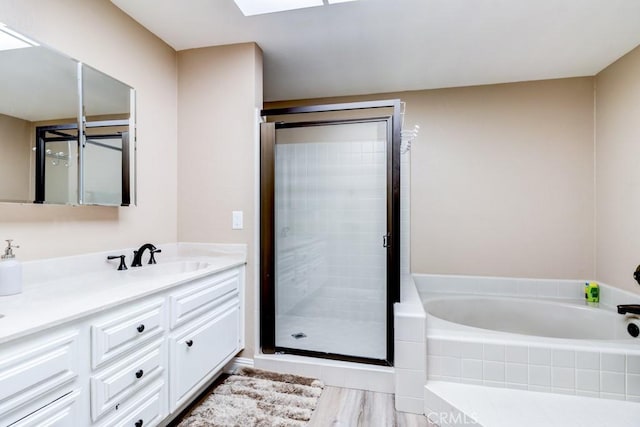 1666 Albany Ct, Claremont, CA 91711 - bathroom featuring a garden tub, double vanity, a shower stall, a skylight, and wood finished floors