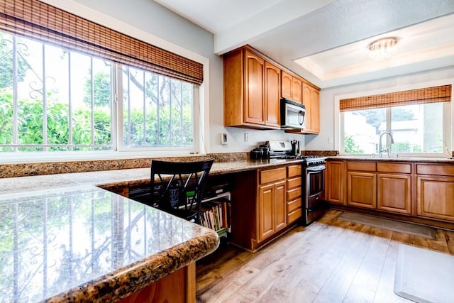 1666 Albany Ct, Claremont, CA 91711 - kitchen with stainless steel appliances, brown cabinetry, light wood finished floors, and stone countertops