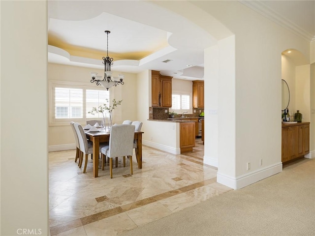 120 Via Alameda, Redondo Beach, CA 90277 - dining room featuring a chandelier, a raised ceiling, baseboards, arched walkways, and ornamental molding