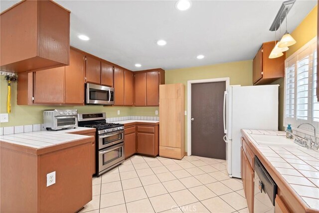 1257 N Brookhurst St, Anaheim, CA 92801 - kitchen featuring appliances with stainless steel finishes, tile countertops, recessed lighting, pendant lighting, and brown cabinets