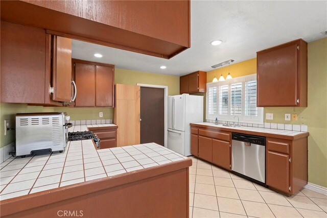 1257 N Brookhurst St, Anaheim, CA 92801 - kitchen featuring dishwasher, freestanding refrigerator, tile counters, a peninsula, and recessed lighting