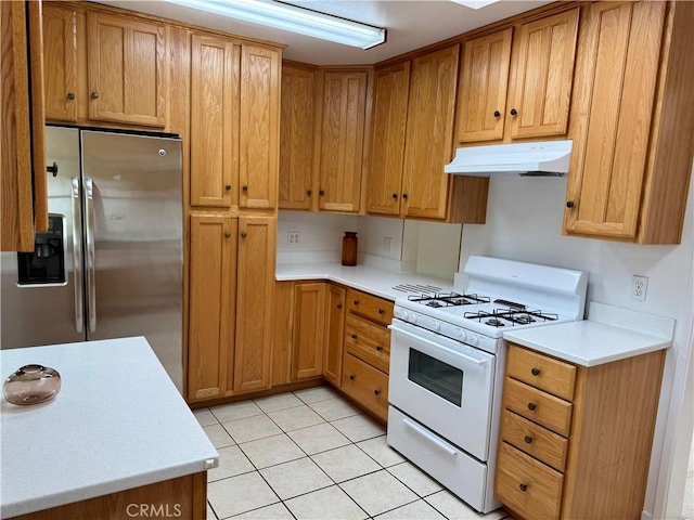 959 Post Rd, Costa Mesa, CA 92626 - kitchen with white gas range oven, under cabinet range hood, stainless steel fridge, and light countertops
