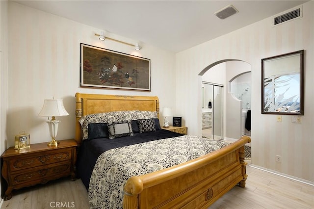 11 Classico Dr, Newport Coast, CA 92657 - bedroom with wallpapered walls, light wood finished floors, arched walkways, and a closet