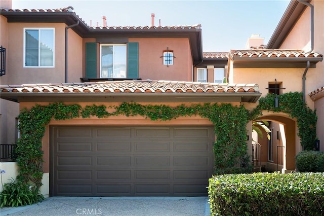 11 Classico Dr, Newport Coast, CA 92657 - mediterranean / spanish-style house with an attached garage, a chimney, a tiled roof, and stucco siding