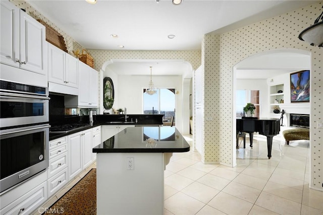 11 Classico Dr, Newport Coast, CA 92657 - kitchen featuring double oven, white cabinetry, a kitchen island, dark countertops, and gas stovetop