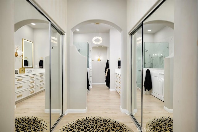 11 Classico Dr, Newport Coast, CA 92657 - hall featuring light wood finished floors, arched walkways, and recessed lighting