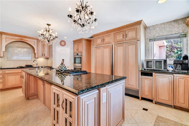 15850 Arbela Dr, Whittier, CA 90603 - kitchen with a chandelier, an island with sink, dark stone counters, decorative backsplash, and recessed lighting