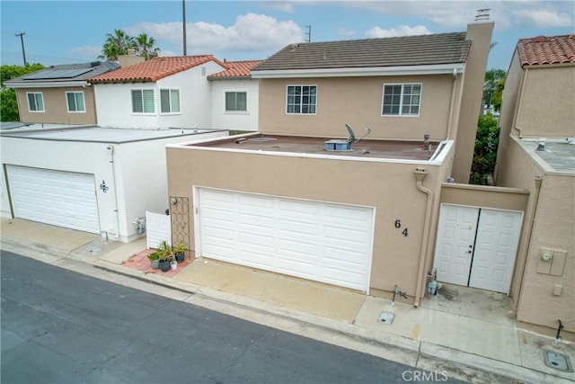 64 Seacrest Ct, Long Beach, CA 90803 - back of house with stucco siding, a chimney, and a garage