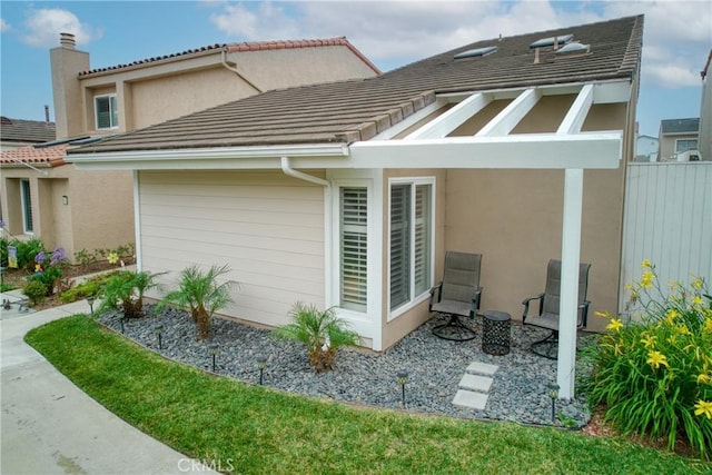 64 Seacrest Ct, Long Beach, CA 90803 - view of home's exterior featuring a garage, stucco siding, a chimney, and a tile roof