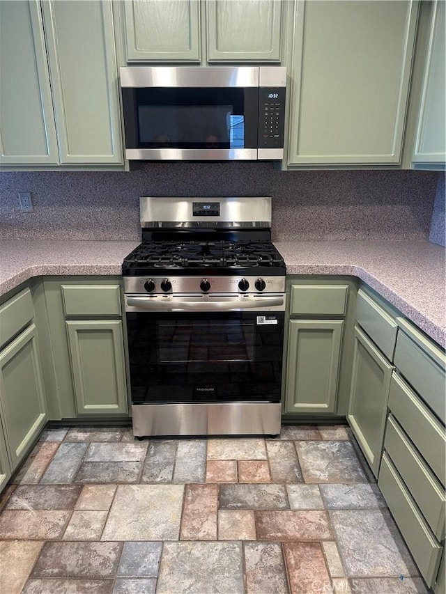 2051 Orizaba Ave Unit 8, Signal Hill, CA 90755 - kitchen with stainless steel appliances, green cabinets, light countertops, and brick patterned floors